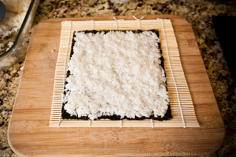 Placing sushi rice onto the nori seaweed