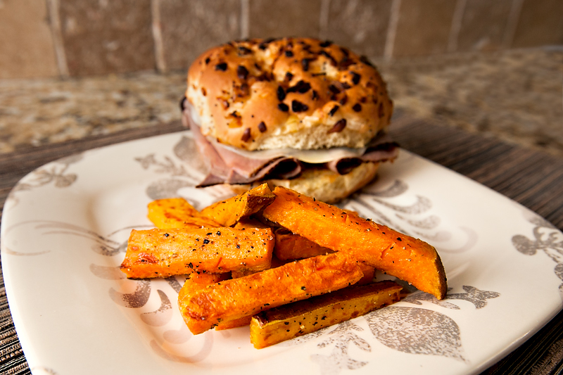 oven baked sweet potato fries with salt and pepper and a roast beef onion roll sandwich