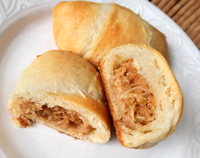 Perfect party food idea or appetizer! Crescent rolls stuffed with shredded chicken mixed with a homemade Thai peanut sauce.