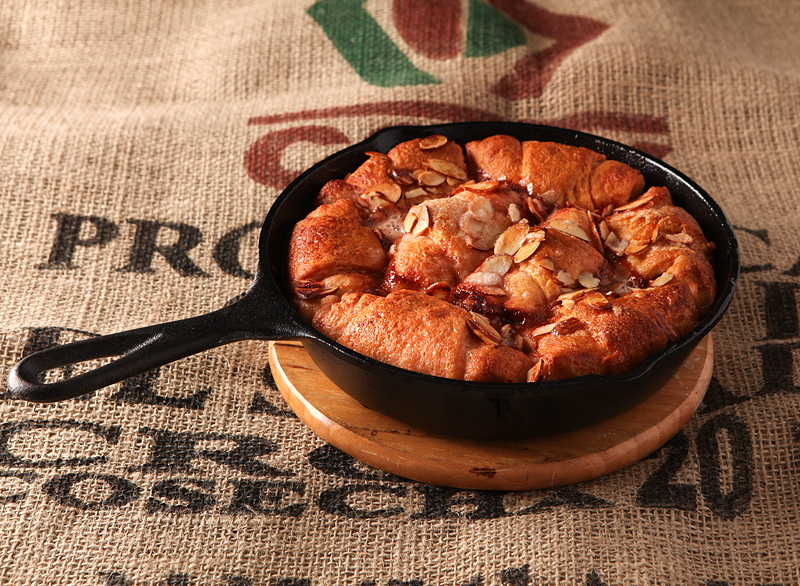 Hot crescent dumplings filled with cherries and covered in a sweet cola glaze and sliced almonds.