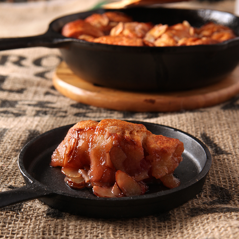 Hot crescent dumplings filled with cherries and covered in a sweet cola glaze and sliced almonds.