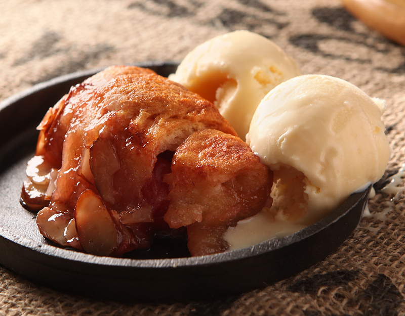 Hot crescent dumplings filled with cherries and covered in a sweet cola glaze and sliced almonds.