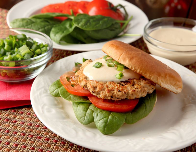 Turkey burgers don't have to be boring! These are loaded with flavors like orange juice and soy and are spread with a low calorie Greek yogurt aioli. 