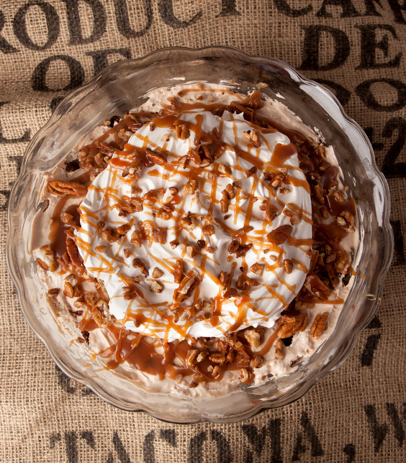 Chocolate turtle trifle - layers of chocolate cake, homemade caramel mousse, pecans, caramel drizzle, and whipped cream make this one amazing dessert that feeds a crowd!