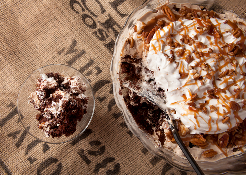 Chocolate turtle trifle - layers of chocolate cake, homemade caramel mousse, pecans, caramel drizzle, and whipped cream make this one amazing dessert that feeds a crowd!