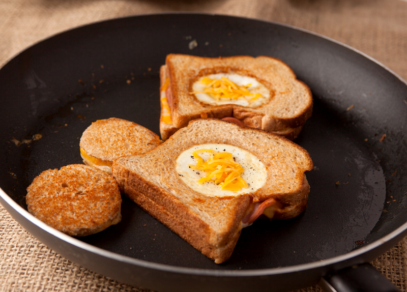 Easy dinner or breakfast idea - eggs in a basket grilled ham and cheese sandwiches. Filling, loaded with protein, and you can use fun cookie cutters for the kids!