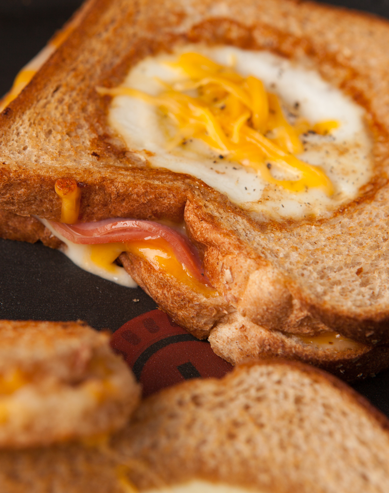 Easy dinner or breakfast idea - eggs in a basket grilled ham and cheese sandwiches. Filling, loaded with protein, and you can use fun cookie cutters for the kids!