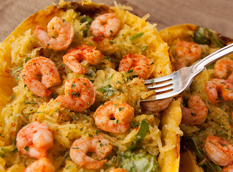 Fantastic low carb dinner idea!  Roasted spaghetti squash is mixed with pesto, parmesan, garlic, and spinach and  served with flavorful sauteed shrimp!