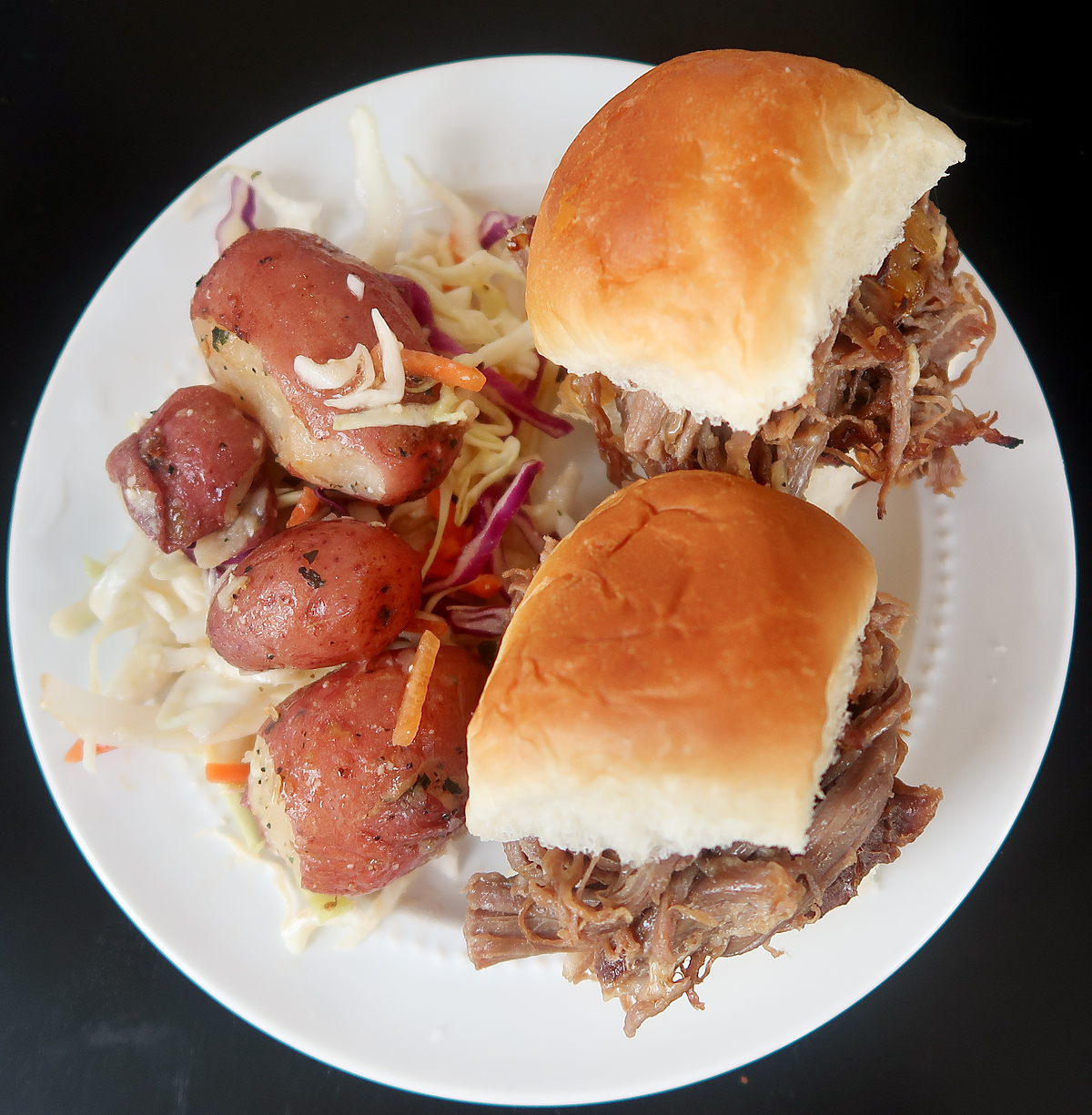 Overhead flat lay of French onion beef sliders with potato slaw