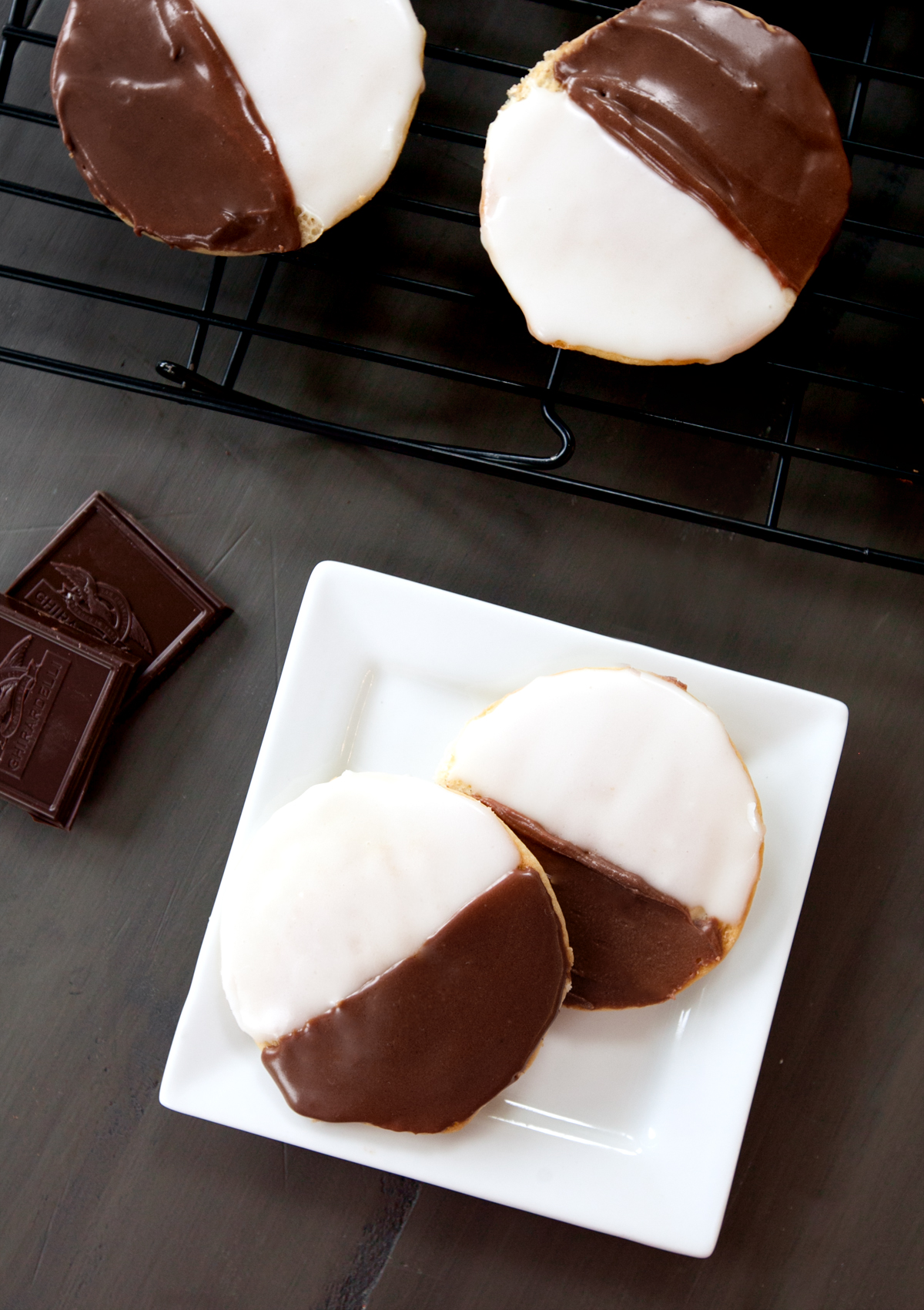 overhead view of black and white half moon cookies sitting on a cookie rack.