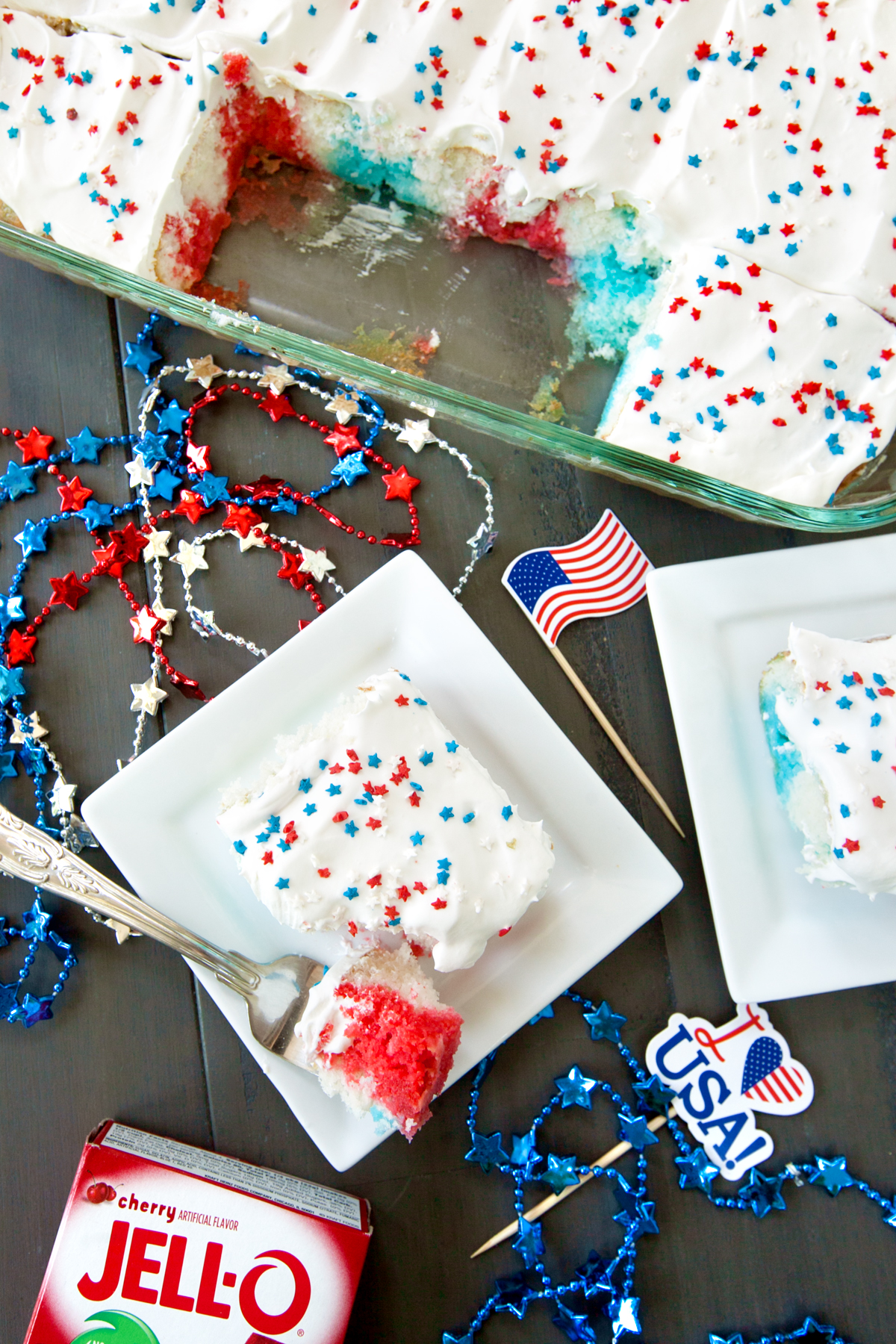 flat lay of red white and blue poke cake with slices on plate