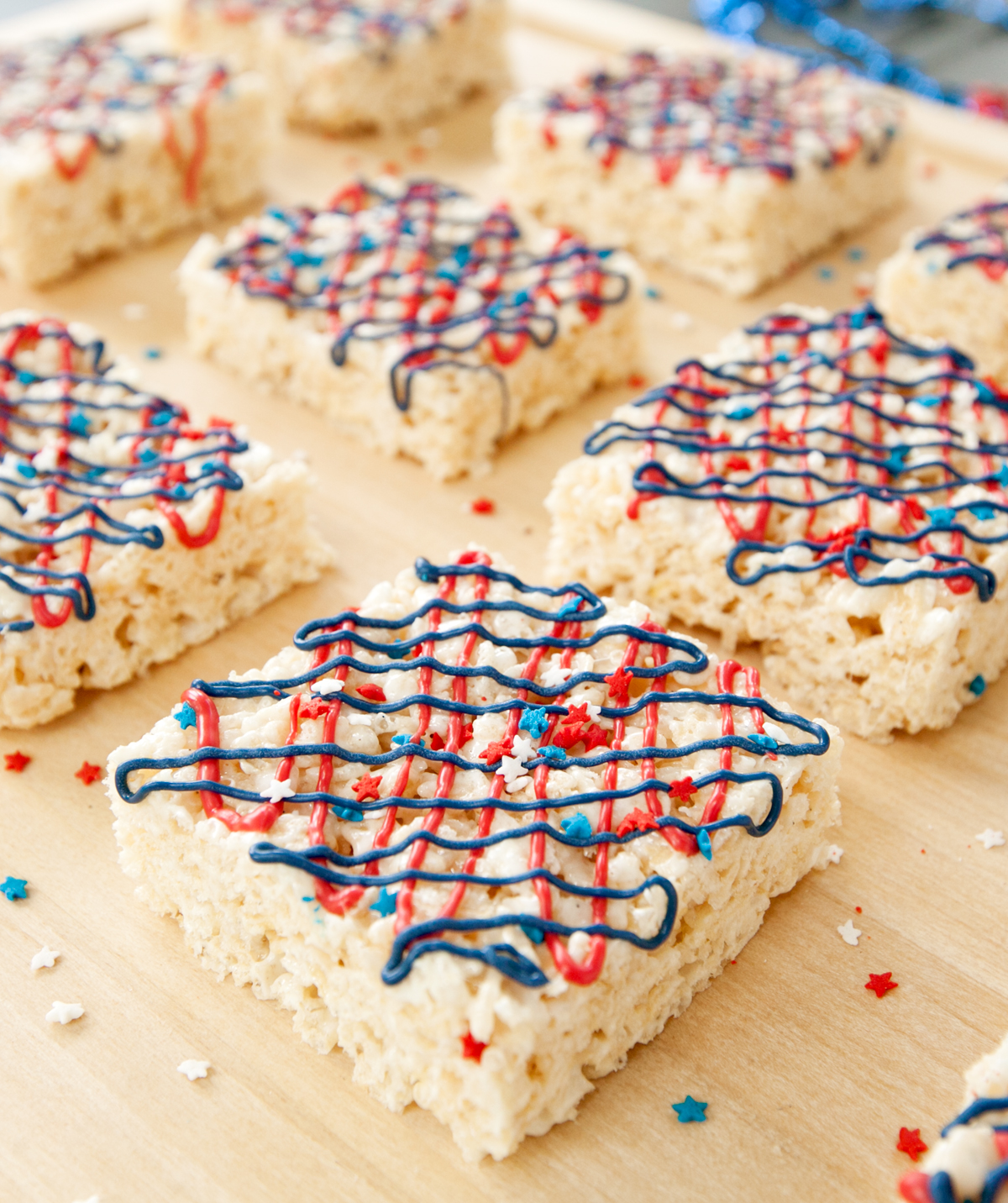 squares of rice krispie treats drizzled with red white and blue frosting