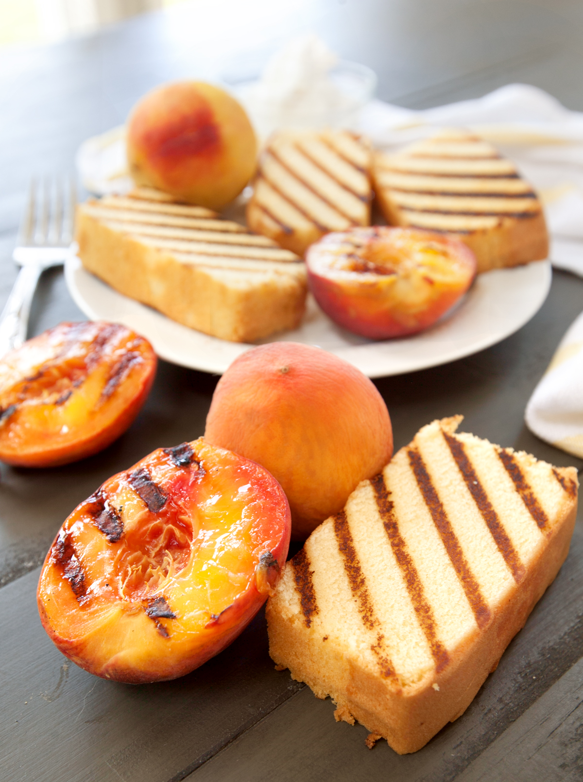 a big plate of grilled pound cake slices with grilled peaches.