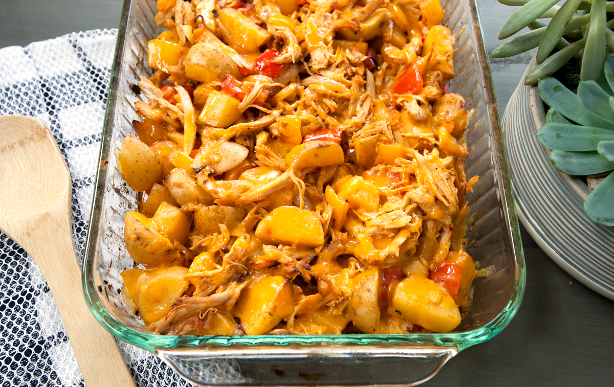 A half view of a pan of cheesy chicken and potato bake