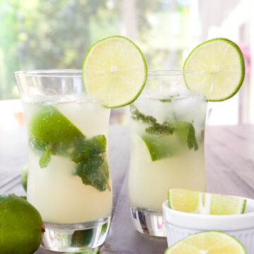 two non alcoholic mojitos with lime slices and mint leaves