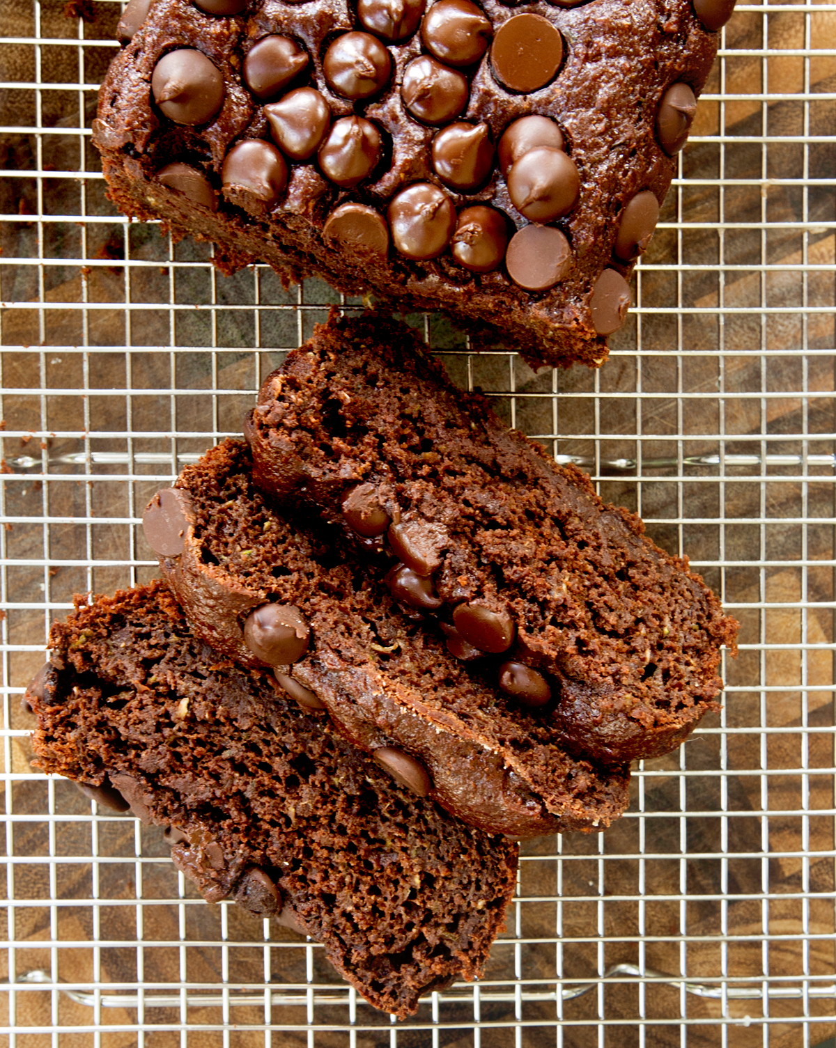 Overhead view of cut up chocolate zucchini bread on a cooling rack.