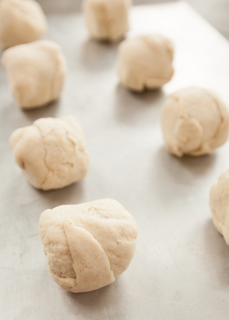 Close up of raw hocus pocus buns with crescent roll dough wrapped around a jumbo marshmallow