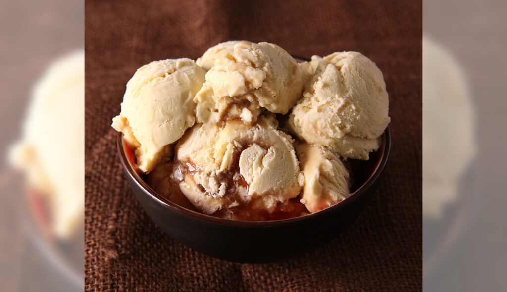 A big bowl scooped high with butterbeer flavored ice cream and cream soda syrup.