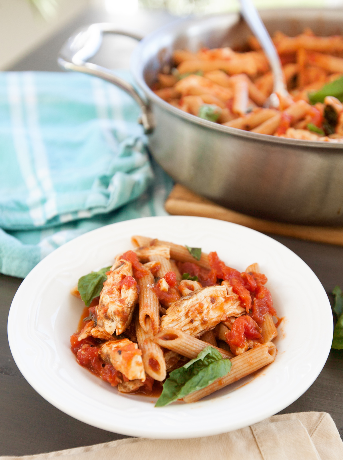 A spicy chicken pasta recipe prepared and dished out into a bowl, garnished with fresh basil.