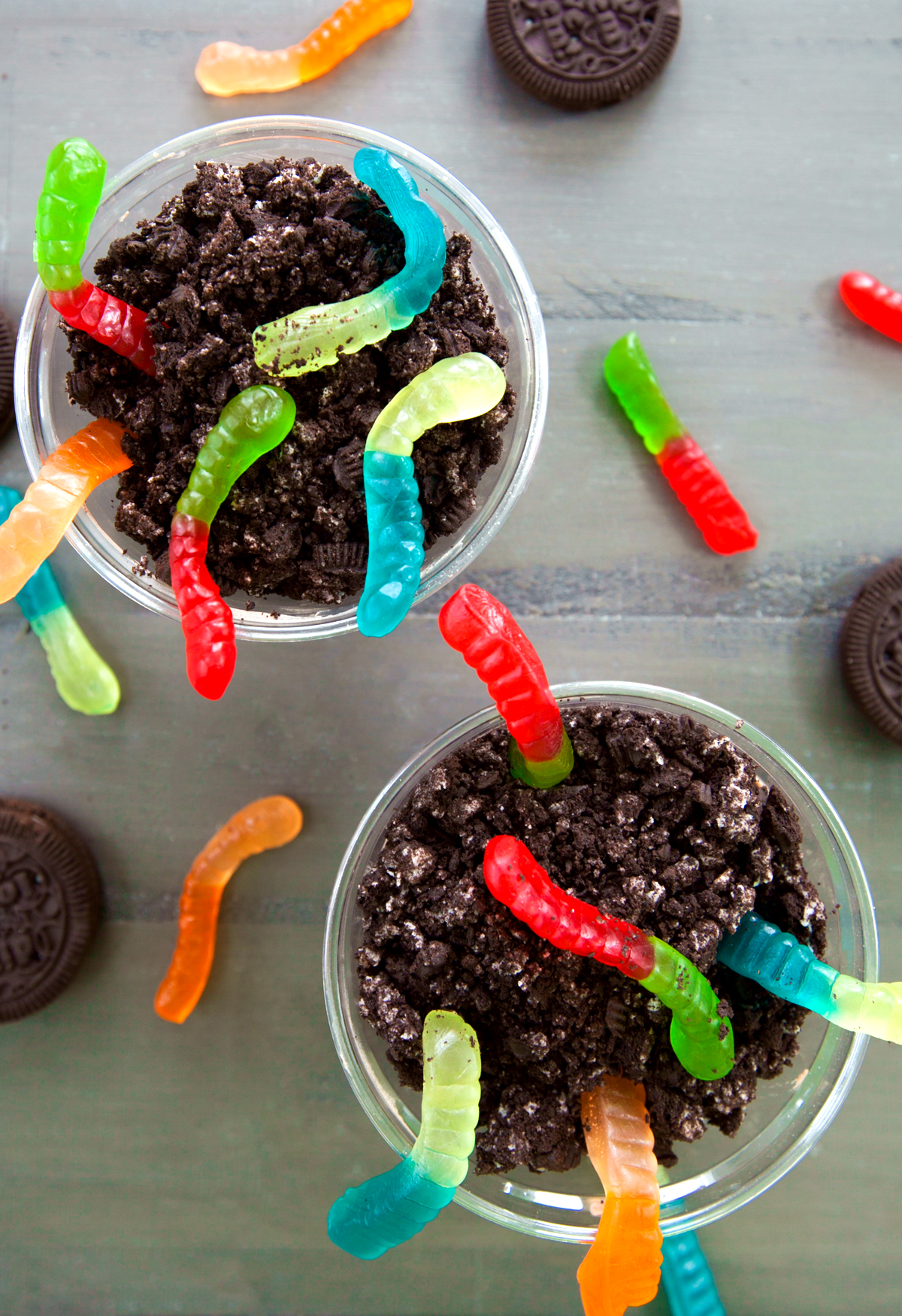 Overhead view of pudding dirt cups with bi-color gummy worms.