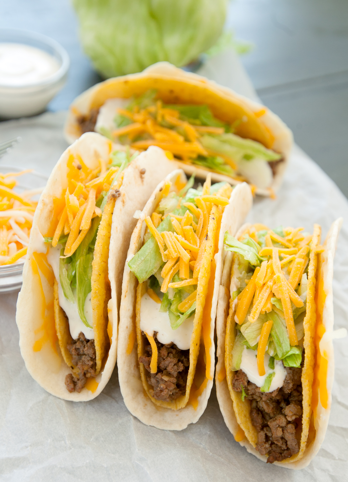 A spread of 3 Taco Bell gordita crunch tacos with layered toppings.