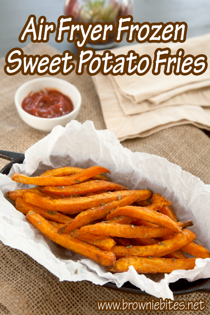 Cast iron container lined with parchment, full of crispy sweet potato fries.