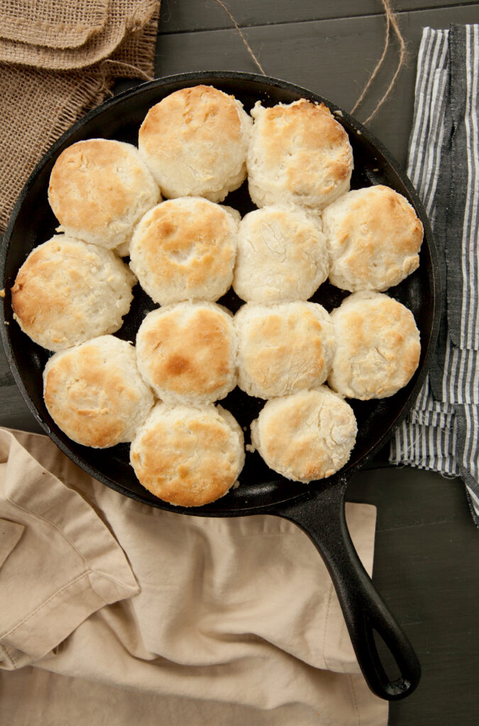 Overhead view of a shallow cast iron skillet of golden Brenda Gantt Biscuits.