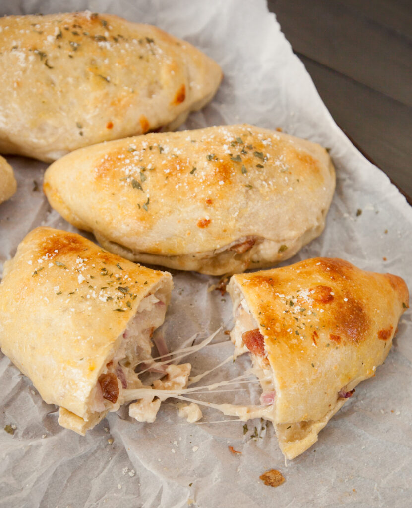 A cheesy calzone being pulled apart to see the yummy insides.