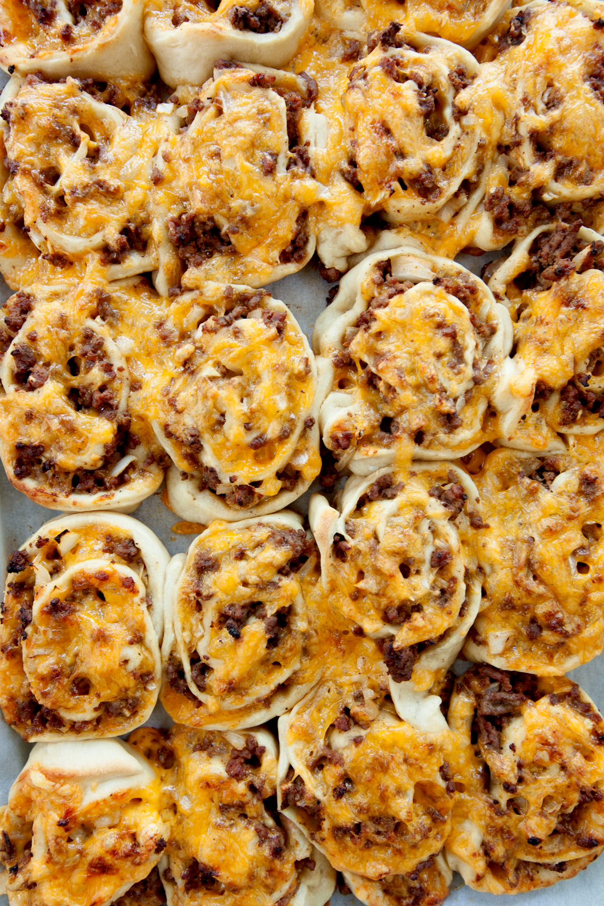 Overhead view of a pan of cheeseburger pinwheels.