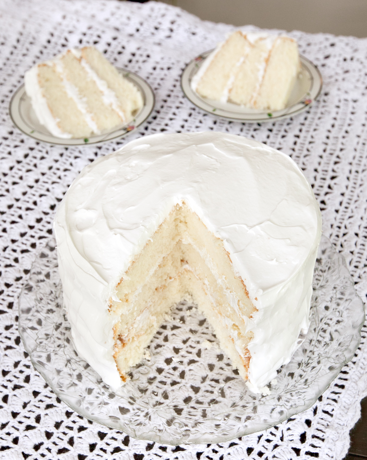 A slightly overhead view of white cake from the movie Django Unchained with slices cut out and sitting behind it.