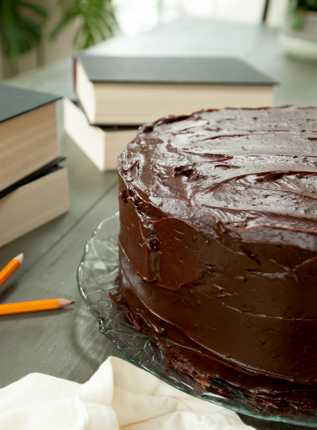 Close up of a glossy triple layer chocolate cake coated with chocolate ganache. A copycat recipe from the movie Matilda.